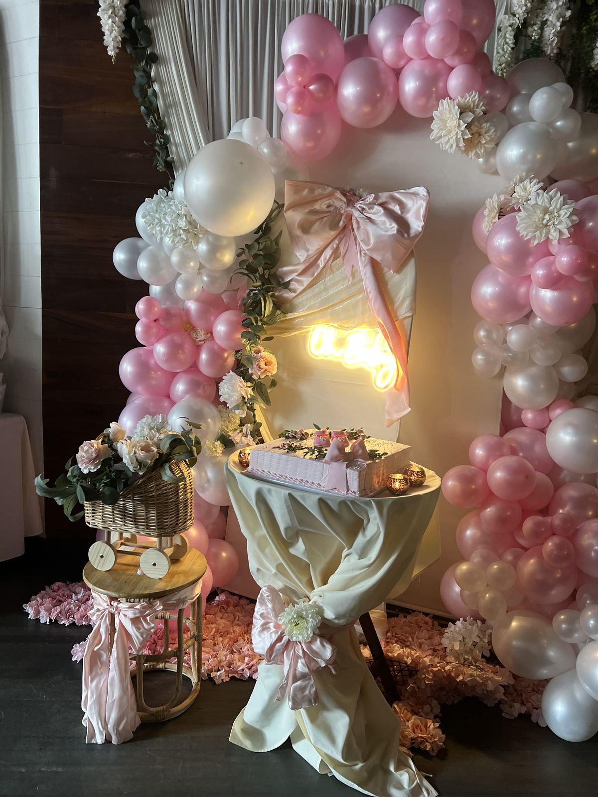 Pink and white balloon arch around a cake table in the Kaskade dining room