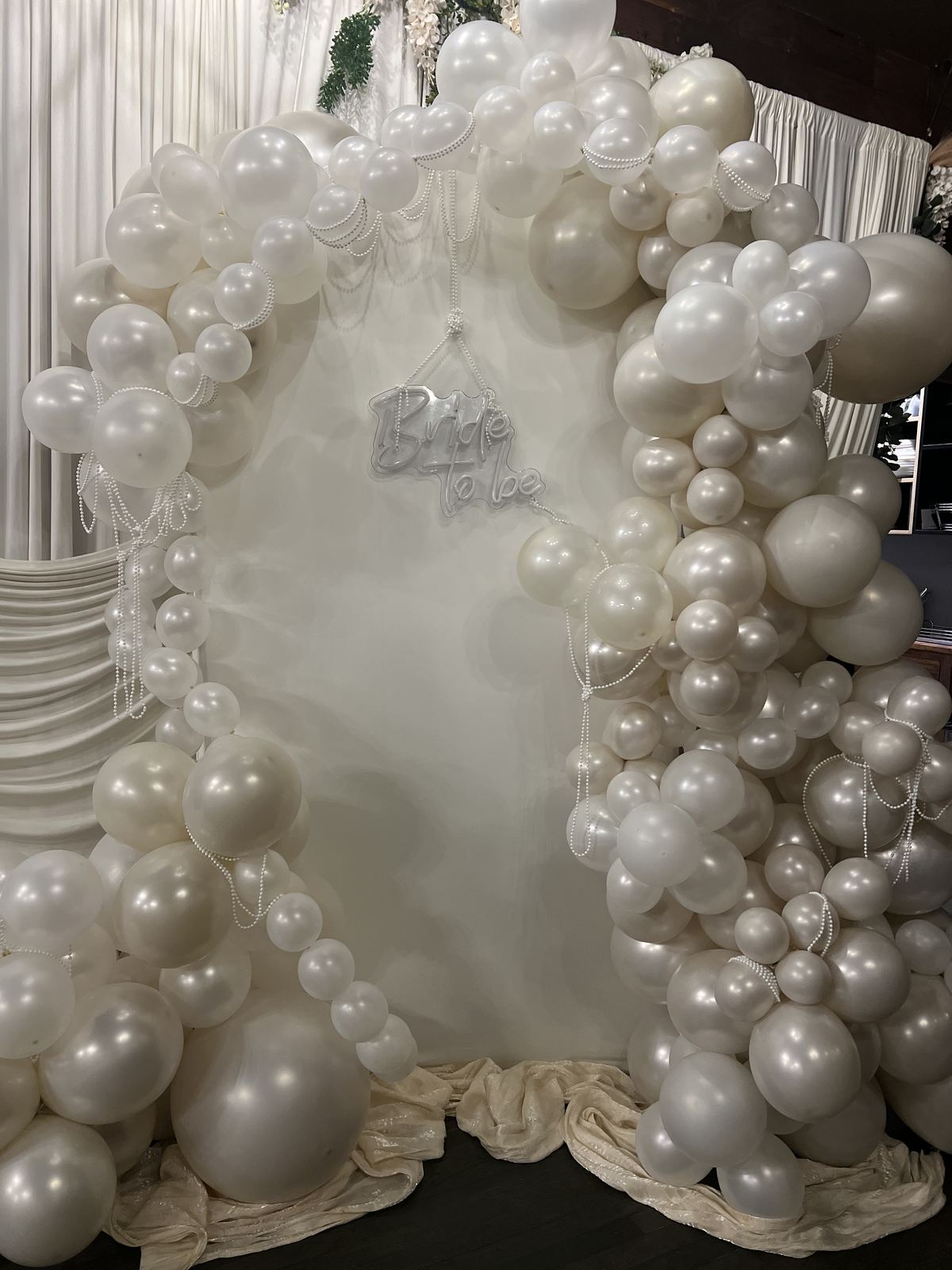 Bridal shower arch of ivory and pearl balloons with a Bride to Be sign at Kaskade