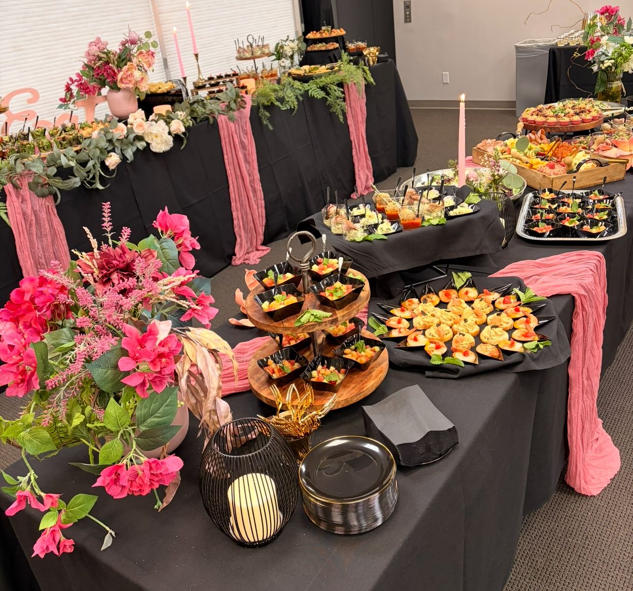 An event buffet catered by Kaskade — canapés, charcuterie and hot dishes laid out with floral styling