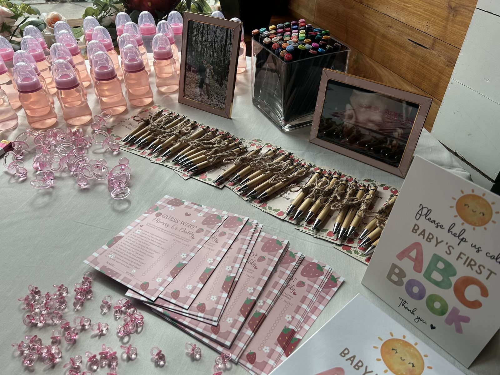 A favour table laid with keepsake bottles, pens and guest game cards