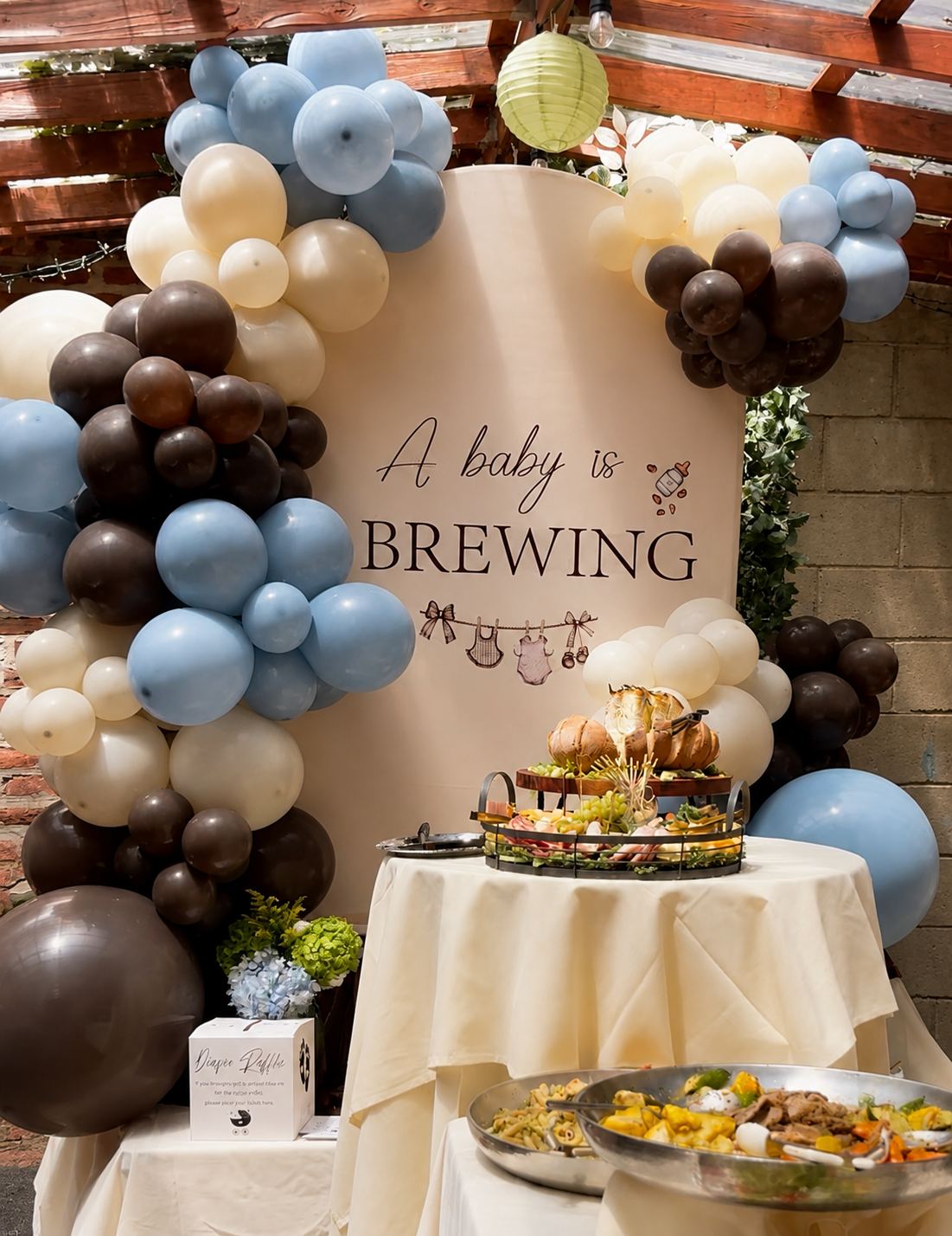 The garden at Kaskade set for a baby shower, with a balloon arch and food table under the pergola